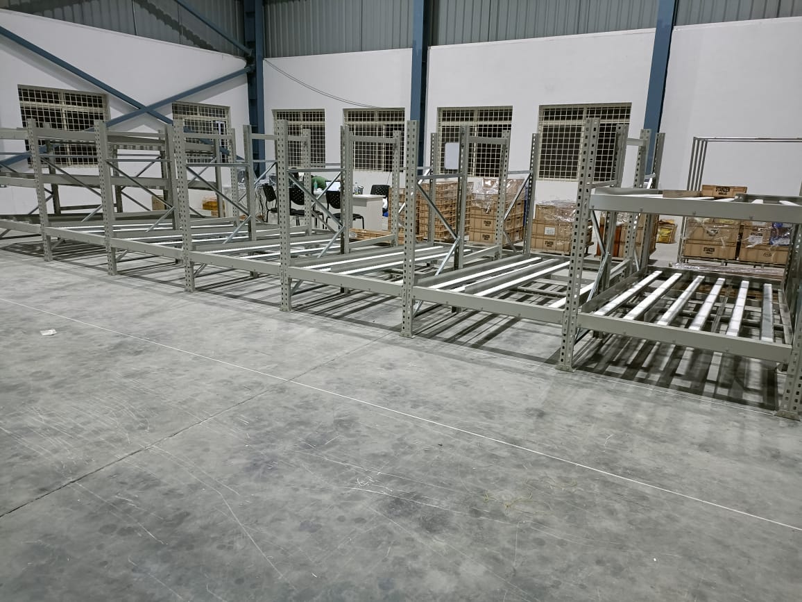 Sistema de estantes FIFO de alta resistência com fluxo por gravidade, rodízios de aço, modular e expansível, capacidade de 1500 kg, revestimento em pó e alta densidade de armazenamento.
