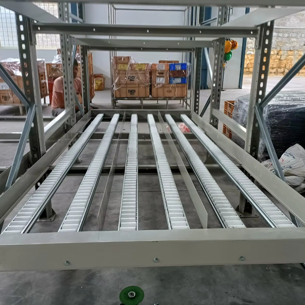 Sistema de estantes FIFO de alta resistência com fluxo por gravidade, rodízios de aço, modular e expansível, capacidade de 1500 kg, revestimento em pó e alta densidade de armazenamento.